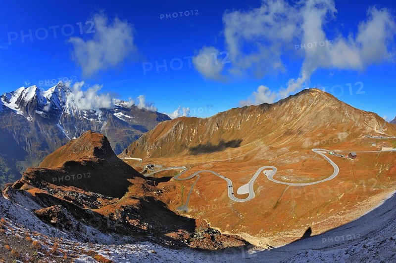 Austrian Alps. Excursion to the picturesque panoramic way Grossgloknershtrasse. Sunny day in early autumn. Great highway winds between hillsides yellowed