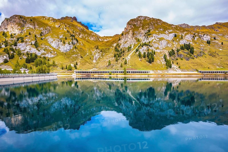 Mountain Lake Lago di Fedadia, Dolomites. Glacial lake with clear cold water. Cool autumn day at Mount Marmolada. The concept of ecological and extreme tourism