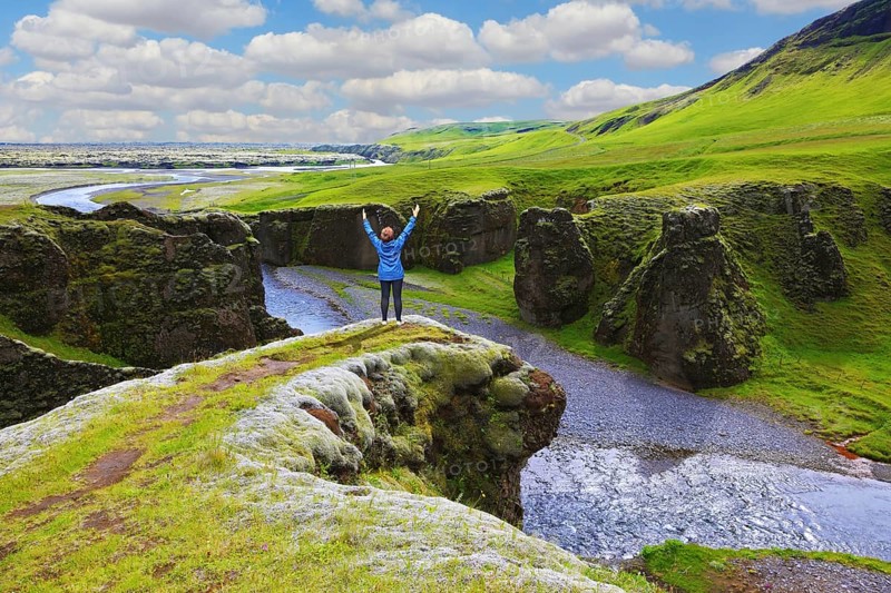 Fantastic country Iceland. Enthusiastic woman - tourist on a rock canyon Fjadrargljufur