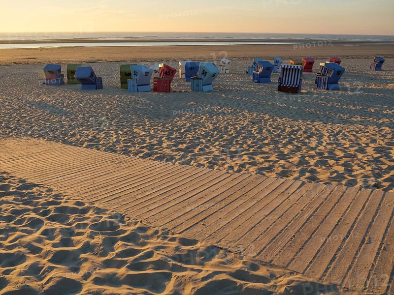 Empty beach chairs scattered on the sandy beach at sunset, langeoog, germany