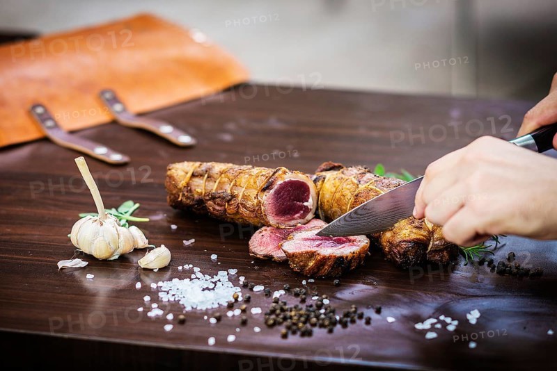 Serving carving roast pork meat roll meal in rustic style with seasonings