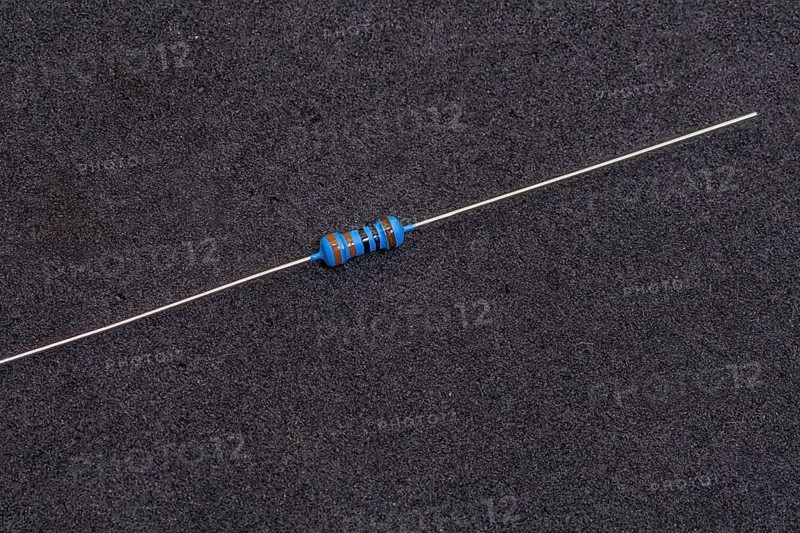 A blue-striped resistor with long leads on a dark background