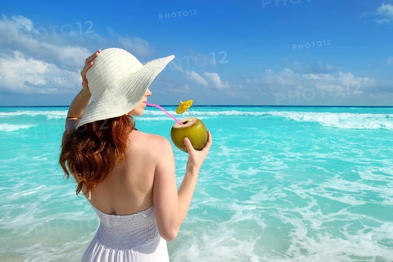 Beach hat profile girl drinking acoconut fresh cocktail in tropical Caribbean sea