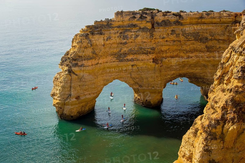 Lagoa, Portugal, September 2022: Kayaks and sup boards peddling under the Arco Natural on the Algarve coast in Portugal, Europe