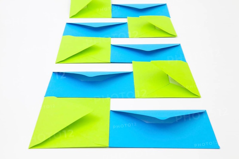 Composition with green and blue envelopes on the white table