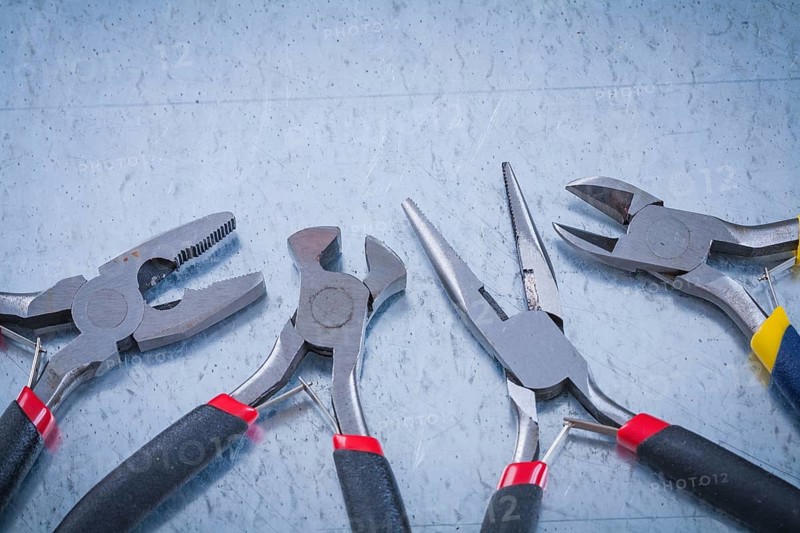 Composition of insulated metal nippers on scratched metallic background