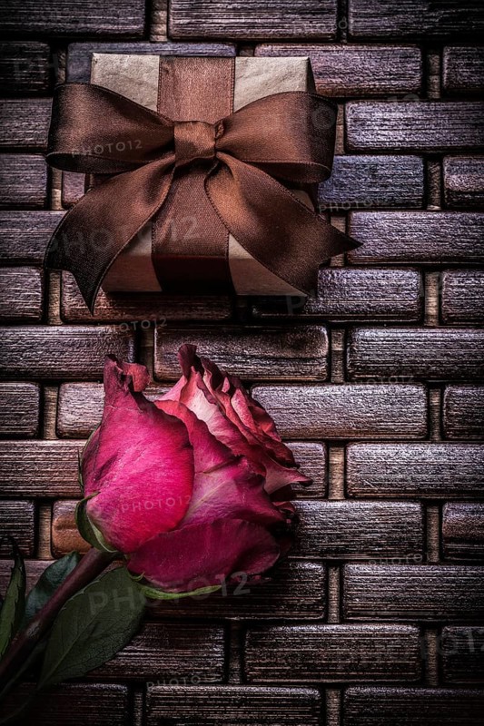 Red scented rose present box on wicker wooden place mat