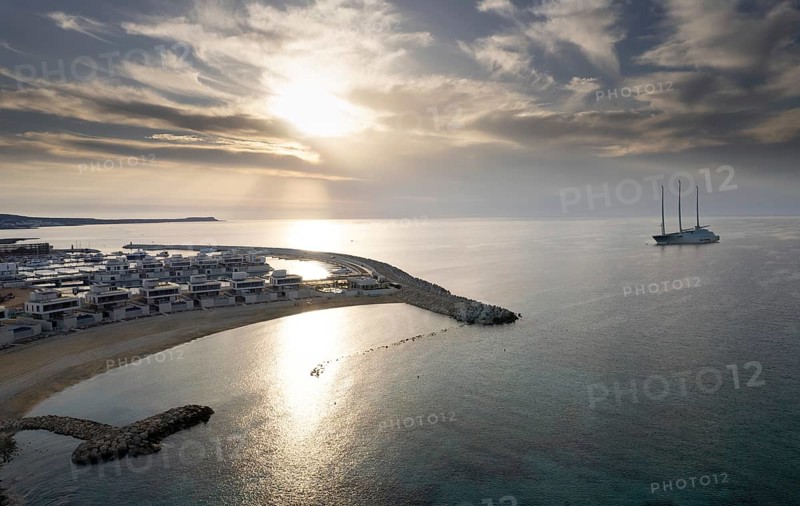 Aerial drone view of a luxury yacht moored outside a harbor at sunrise. Ayia Napa new marina Cyprus