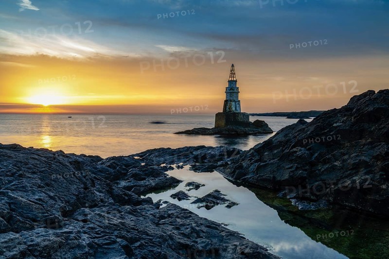 The Athopol Lighthouse on the Black Sea coast of Bulgaria with tidal pools in the foreground at sunrise