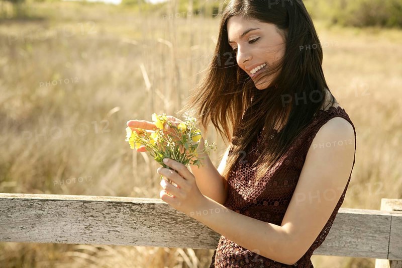 Beautiful woman in golden outdoor with yellow flower