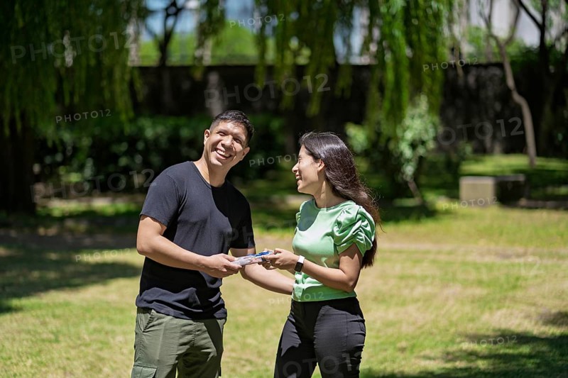 Hispanic couple in a park with a gift in their hands