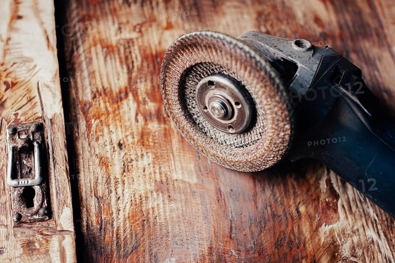 Close-up of an angle grinder on a textured wooden surface