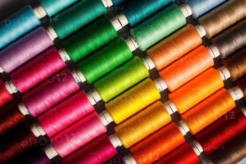 Sewing threads multicolored background closeup