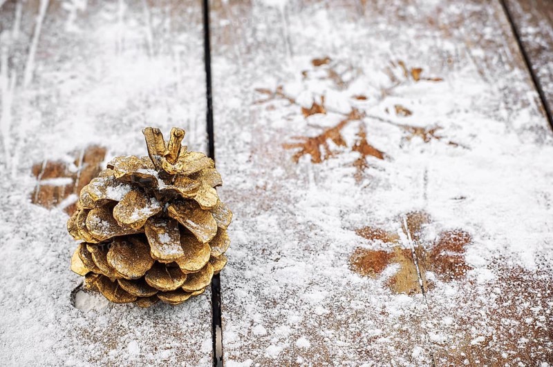 Cedar tower painted in gold colour on a snowy wooden background