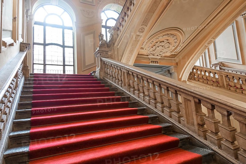 Turin, Italy, January 2023: Palazzo Barolo staircase. Luxury palace with old baroque interior and red carpet, Europe