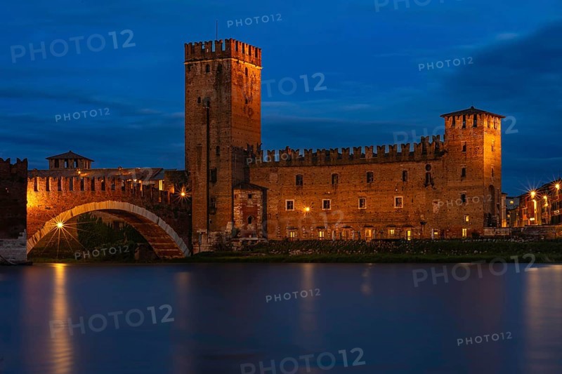 Majestic castle with bridge illuminated against the night sky with mirror-smooth river, at the blue hour, above the river Adige, Museo di Castelvecchio, Ponte Scaligero, Verona, Veneto region, Italy, Europe