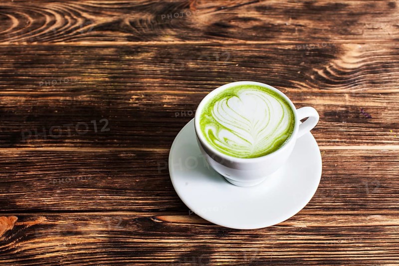 Top view of the cup Matcha latte on wooden background. The concept of green tea as an art