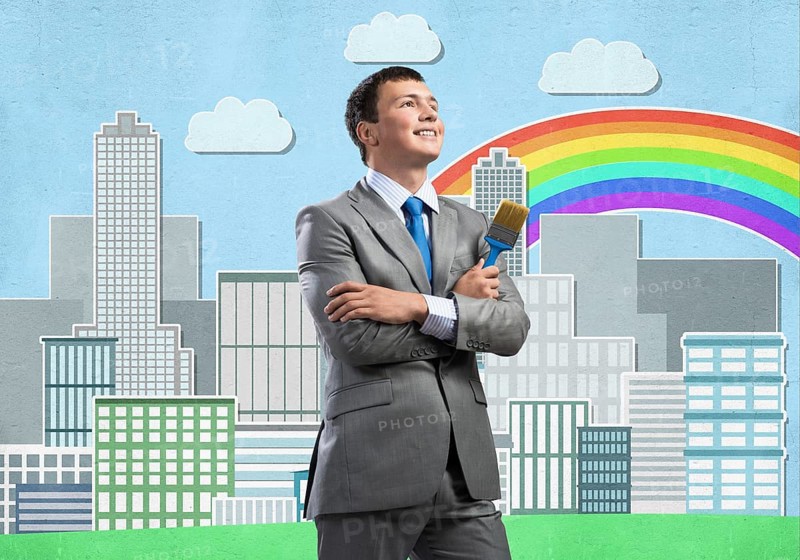 Confident and creative businessman painter standing with arms folded. Happy handsome man in business suit and tie holding paintbrush on city background. Cityscape illustration with colorful rainbow