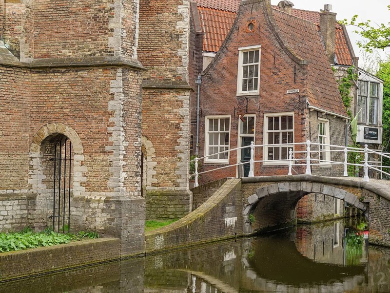 Historic brick building on a canal with small bridges and green surroundings, Delft, Netherlands