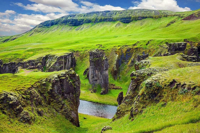 Bizarre shape of cliffs surround the stream with glacial water. The striking canyon in Iceland. The concept of active tourism