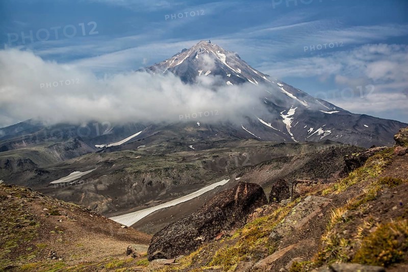 Mountains and volcanoes. Beautiful landscape of Kamchatka Peninsula: summer panoramic view of Mountain Range Vachkazhets, mountain lake and clouds in blue sky on sunny day. Eurasia, Russian Far East, Kamchatka Region
