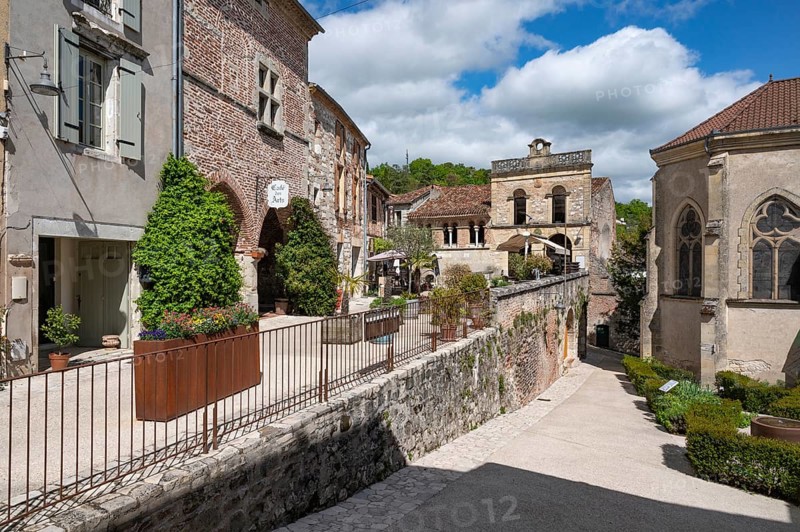 ThePlace Paul Froment with the Cafe des Arts and the Eglise de Marcandiel, corsten steel planter and town palace in one of the most beautiful villages in France, Penne-d'Agenais, Département Lot-et-Garonne, Region Nouvelle-Aquitaine, France, Europe