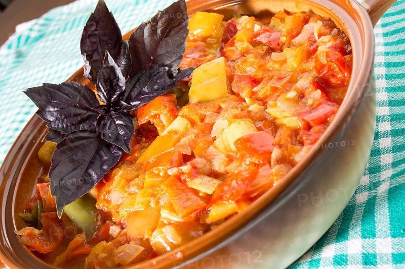 Closeup of delicious stew with mixed vegetables, arranged with green and purple leaves