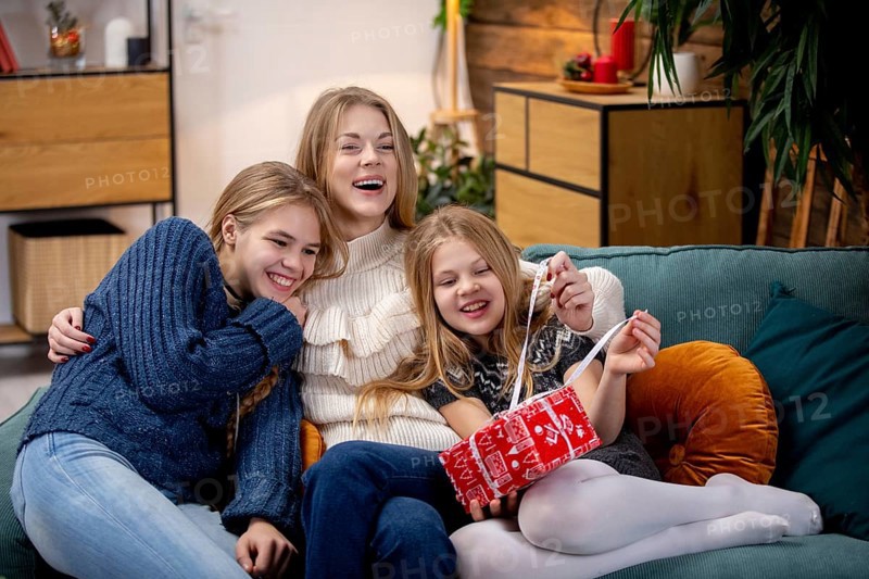 Three happy kids are joyfully sharing a playful moment on a cozy sofa, capturing the essence of friendship