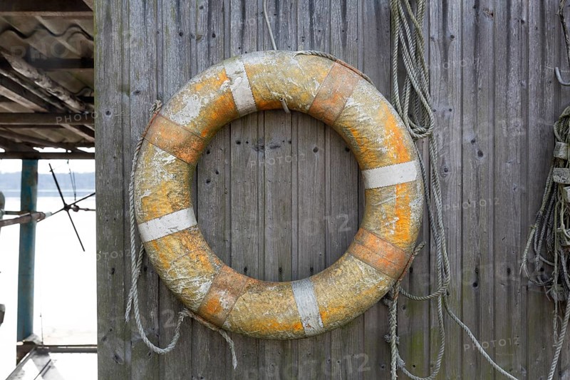 Old lifebuoy on a plank wall