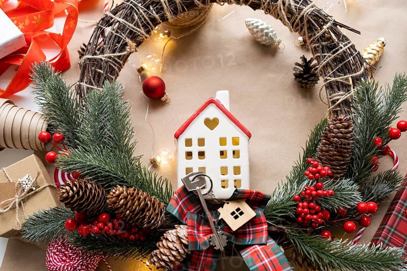 Key to the house with a keychain on a cozy home with a Christmas decor layout. A gift for New Year, Christmas. Building, design, project, moving to new house, mortgage, rent and purchase real estate