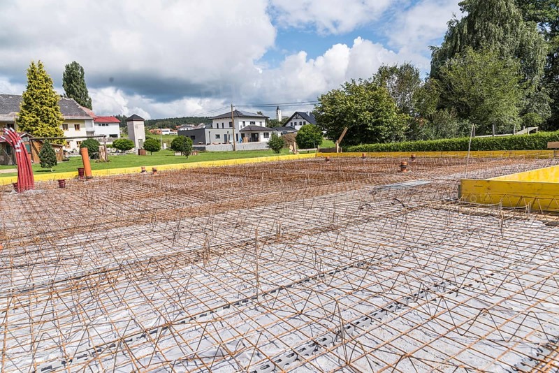 House construction site with steel grid for concrete foundation slab, construction industry