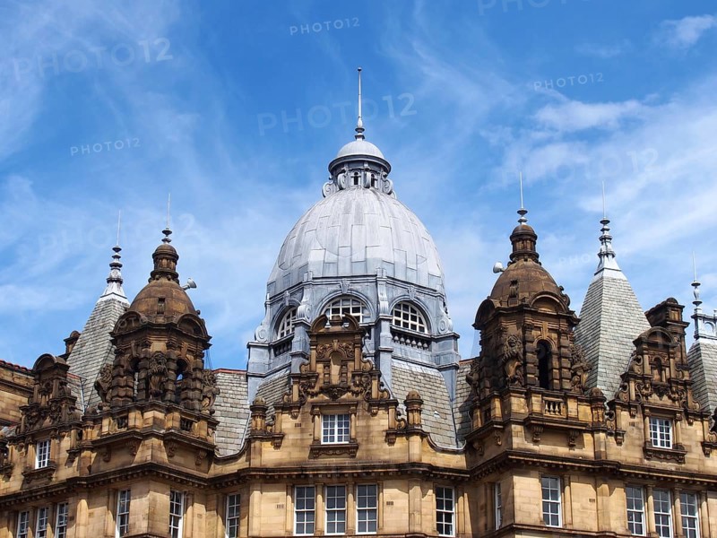 Ornate stone towers and domes on the roof of leeds city market a historical building in west yorkshire england