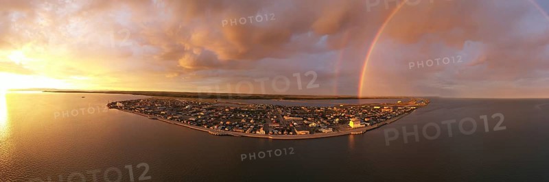 Rain falls as sun shines in the middle of the night at Kotzebue Alaska creating a beautiful contrast between the sunrise and storm