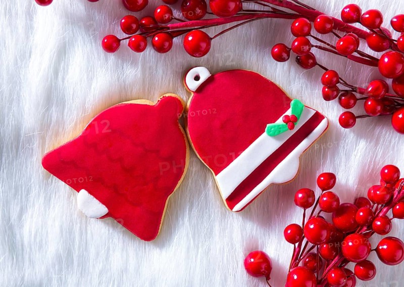Christmas cookies Xmas red bell shape on white fur background