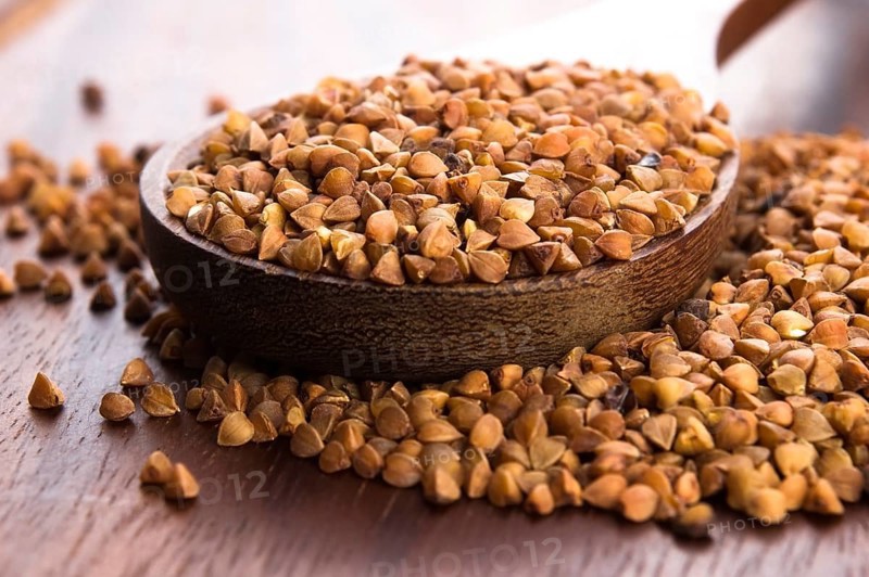 Buckwheat seeds on wooden spoon in closeup, lodz, poland