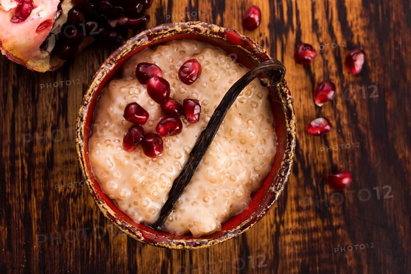 A bowl of tapioca pudding with vanilla and pomegranate