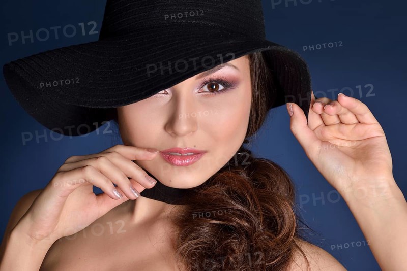 Head of the beautiful woman with long hair in a big blck hat