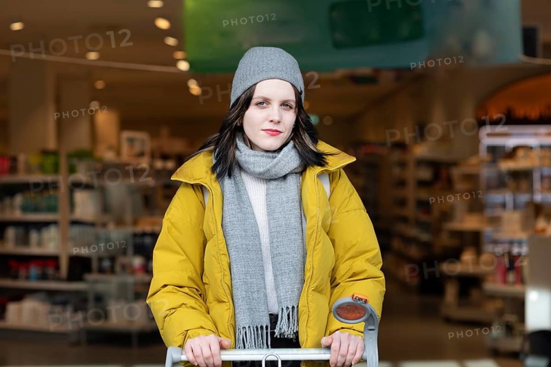 Woman in winter clothes shopping with a shopping trolley on foot, mobility, environmentally friendly