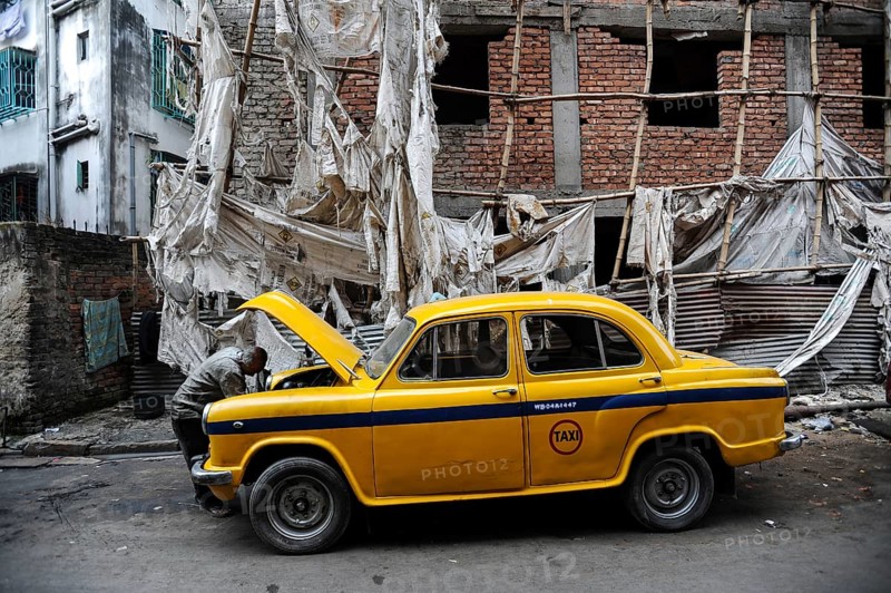 03.12.2011, Kolkata (Calcutta), West Bengal, India, Asia, A taxi driver looks under the bonnet of his yellow Hindustan Ambassador taxi. The Ambassador was the first car manufactured in India and was produced from 1958 to 2014, Asia
