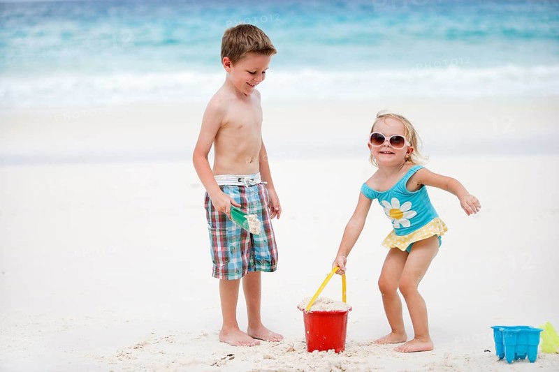 Boy and girl playing in the sand on the beach, La Digue, Indian Ocean, Seychelles, Africa