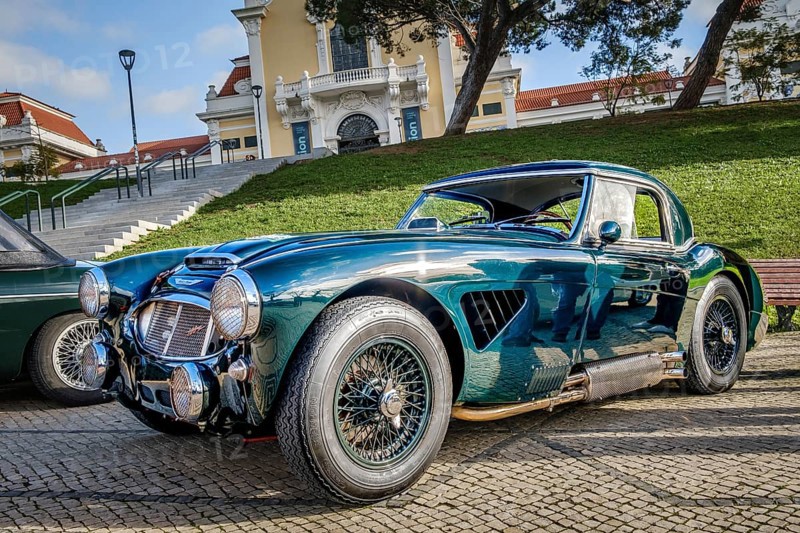 Lisbon, Portugal, Jan 20, 2024: Vintage green Austin Healey 3000 sports car on cobblestone near green park. 2-door 2-seater roadster with hardtop by Austin-Healey BMC, Europe