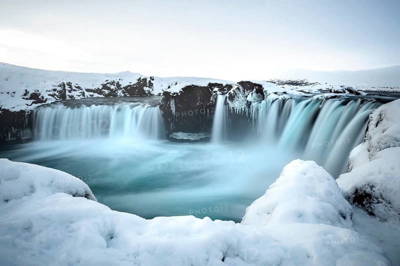 A majestic waterfall surrounded by snow and ice in a wintry landscape, Iceland, Godafoss, Europe