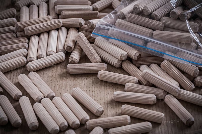 Composition of wooden dowels on wood board construction concept