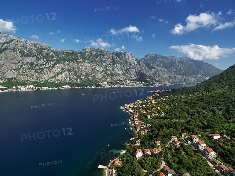 Resort town on the shores of the Bay of Kotor among green trees at the foot of the mountains. Montenegro. Drone., Kotor Municipality, Montenegro, Europe