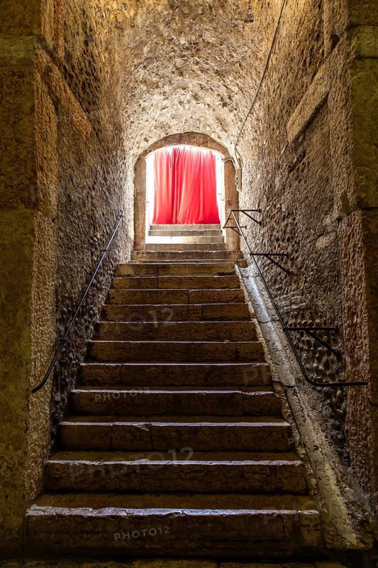 Old corridor with red curtain at the end. Concept for mystery, gothic, escape, hope