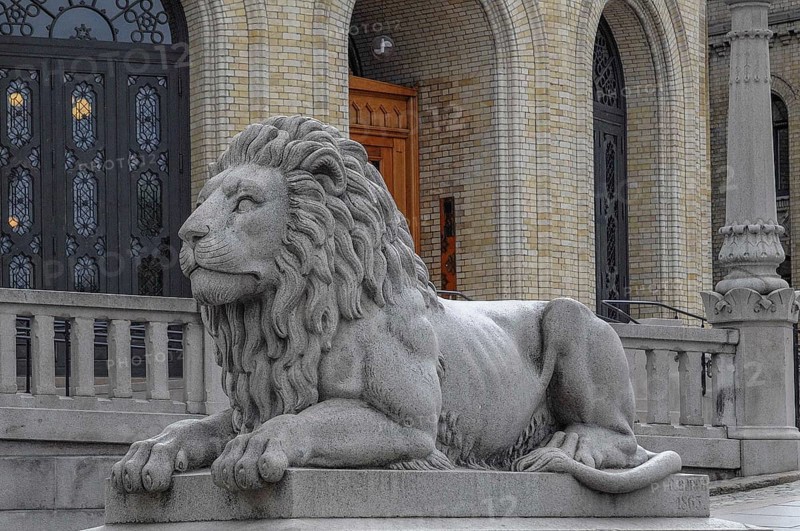 Magnificent stone lion statue in front of a historic building, oslo, norway