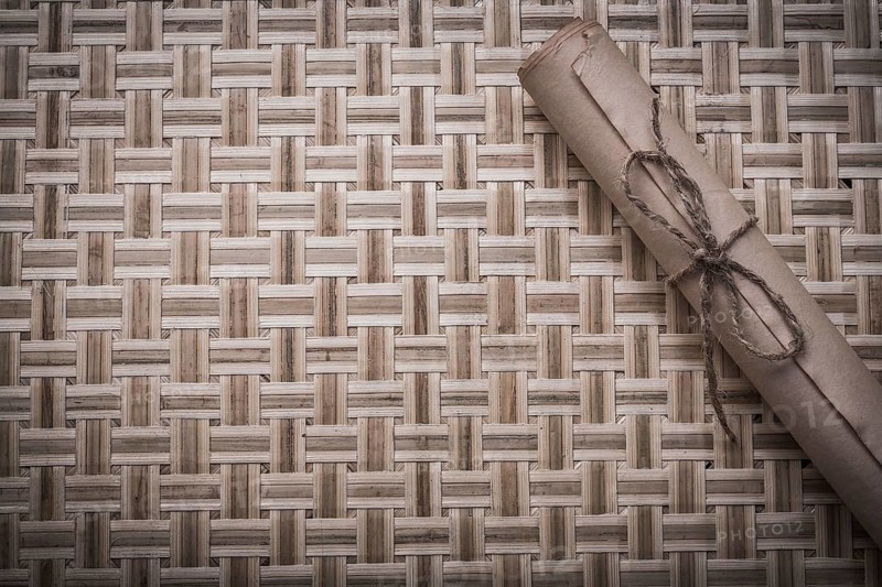 Vintage rolled corded paper on woven wooden matting