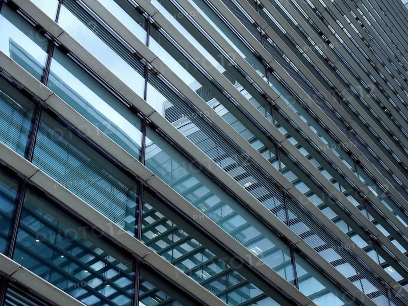 A full frame modern office architecture abstract with geometric shapes and buildings reflected in blue glass windows