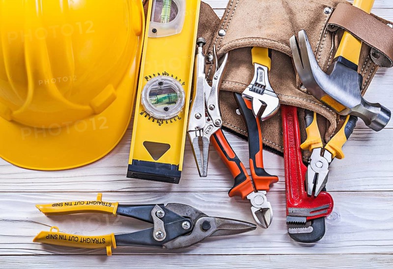 Composition of building implements leather tool belt building helmet on wooden board
