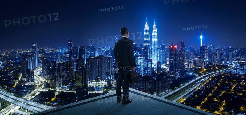 Businessman stand at rooftop looking great cityscape view and thinking business plan of the future . Night scene